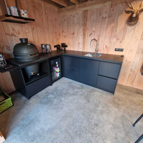 Buitenkeuken in de hoek met barbecue op verrijdbare trolley