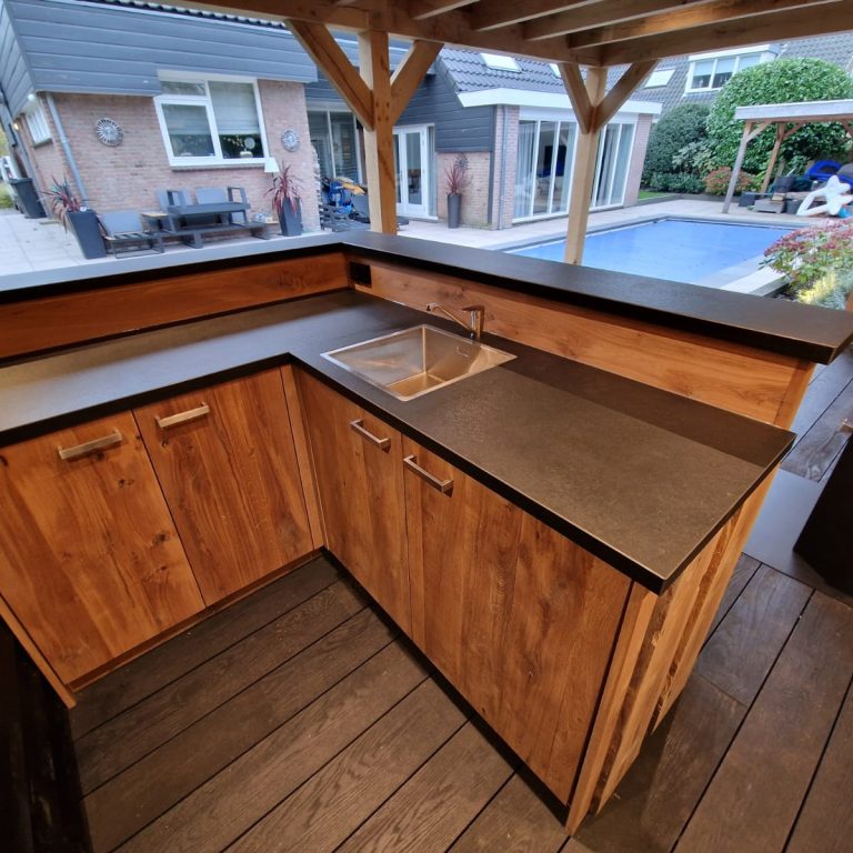 Maatwerk buitenbar geplaatst onder een veranda. Met opbergruimte en wastafel.